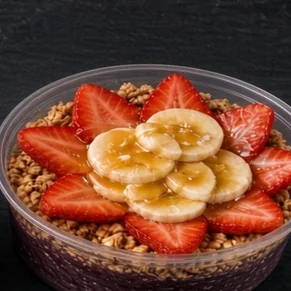 Açaí Treat bowl: açaí base with granola, strawberries, banana slices and a honey drizzle