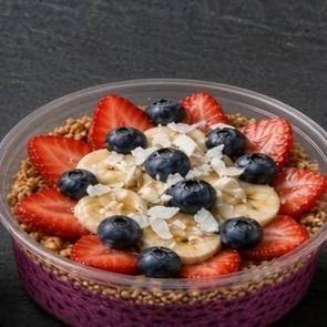 Pink Berry bowl: dragon fruit base with granola, strawberries, banana slices and blueberries